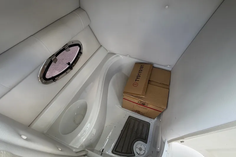 Slide: The Image of Interior of a Crownline Eclipse E235 XS with a small window and boxes. - 27