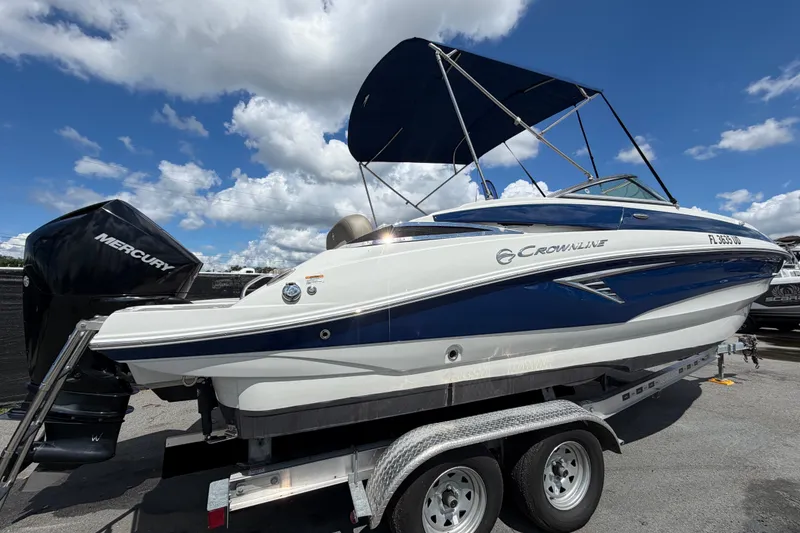 Slide: The Image of 2023 Crownline Eclipse E235 XS boat on trailer under blue sky. - 2