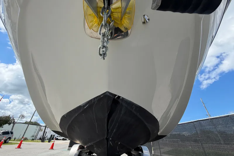 Slide: The Image of 2023 Crownline Eclipse E235 XS boat hull, viewed from below, with clear sky background. - 11