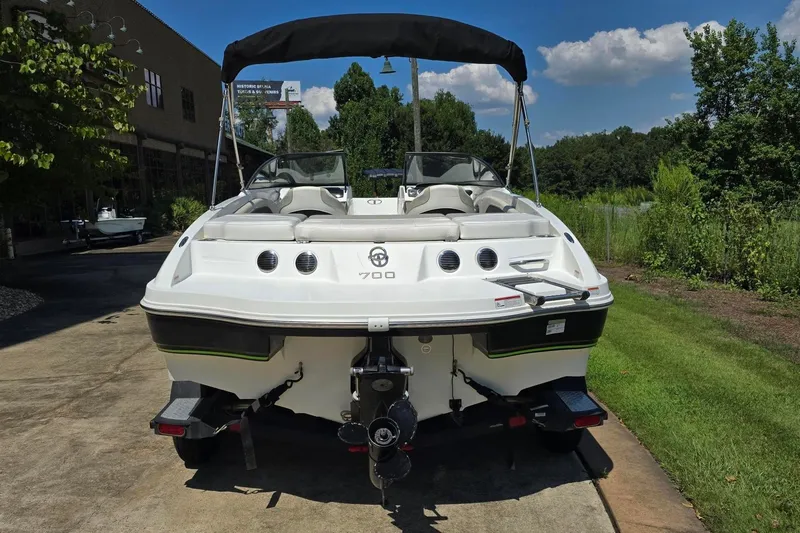 Slide: The Image of 2018 Tahoe 700 boat, rear view, parked outdoors on a sunny day. - 2