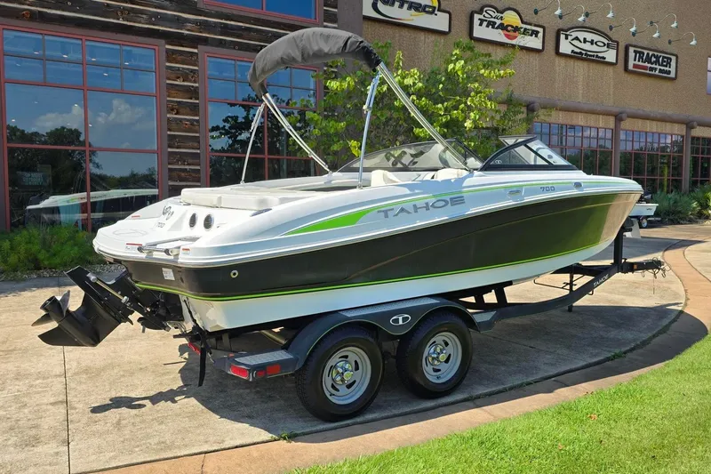 Slide: The Image of 2018 Tahoe 700 boat on trailer, parked outside dealership with signage. - 3