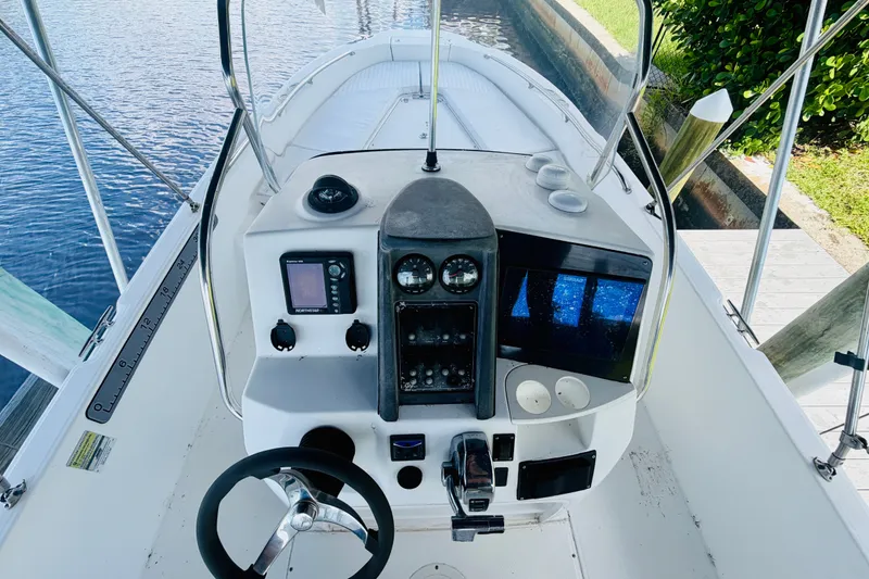 Slide: The Image of 2006 Boston Whaler 230 Dauntless boat cockpit with steering wheel and navigation equipment. - 19