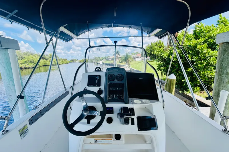 Slide: The Image of 2006 Boston Whaler 230 Dauntless boat cockpit with steering wheel and navigation equipment. - 14