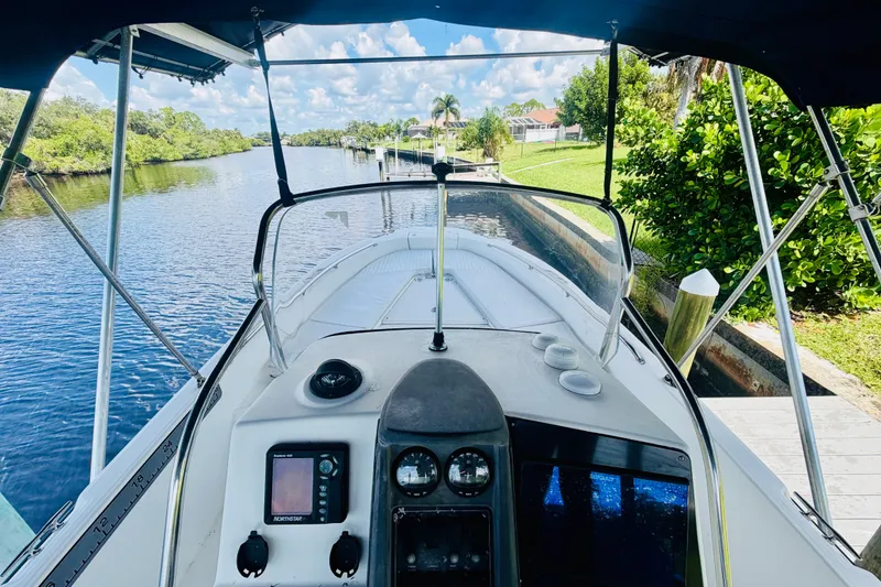 Slide: The Image of Boston Whaler 230 Dauntless 2006 boat on a scenic river with lush greenery. - 20