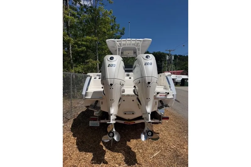 Slide: The Image of 2026 Robalo R270 Center Console boat with dual outboard engines, parked outdoors. - 3