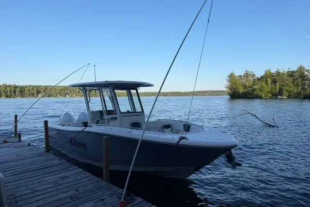 Slide: The Image of 2026 Robalo R270 Center Console boat docked on a serene lake. - 1