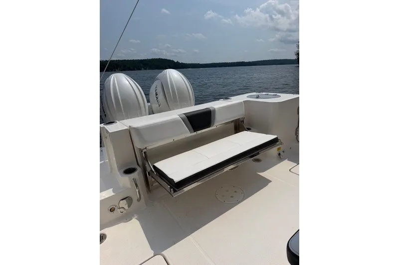 Slide: The Image of 2026 Robalo R270 Center Console boat with foldable seating, dual engines, and scenic lake view. - 26