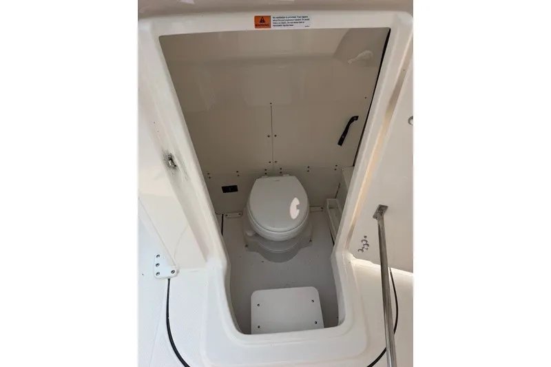Slide: The Image of 2026 Robalo R270 Center Console boat interior with compact marine toilet. - 35