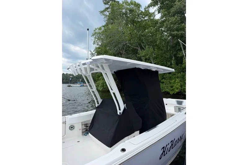 Slide: The Image of 2026 Robalo R270 Center Console boat docked by a scenic lakeside. - 6