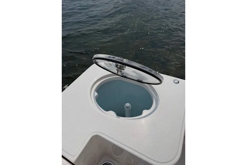 Slide: The Image of 2026 Robalo R270 Center Console livewell with open lid, near water. - 39