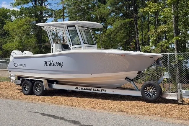 Slide: The Image of 2026 Robalo R270 Center Console boat on trailer, parked outdoors. - 2
