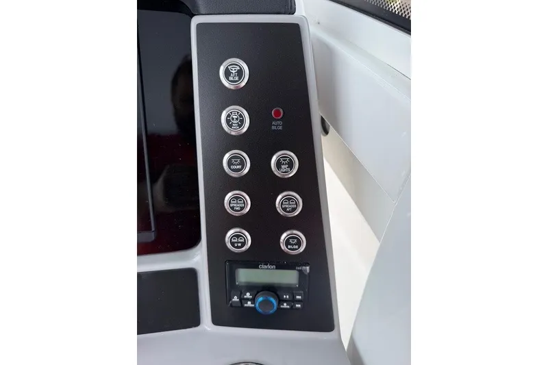 Slide: The Image of Control panel of 2026 Robalo R270 Center Console boat with various switches and Clarion audio system. - 17