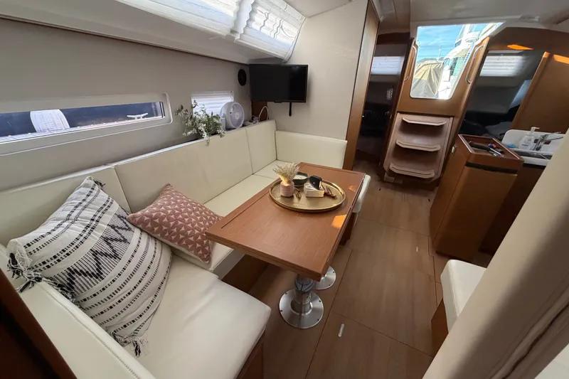 Slide: The Image of Interior of 2024 Jeanneau Sun Odyssey 410 yacht with elegant seating and dining area. - 14