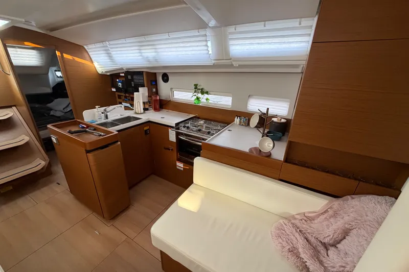 Slide: The Image of Interior of 2024 Jeanneau Sun Odyssey 410 yacht, featuring modern kitchen and cozy seating area. - 13
