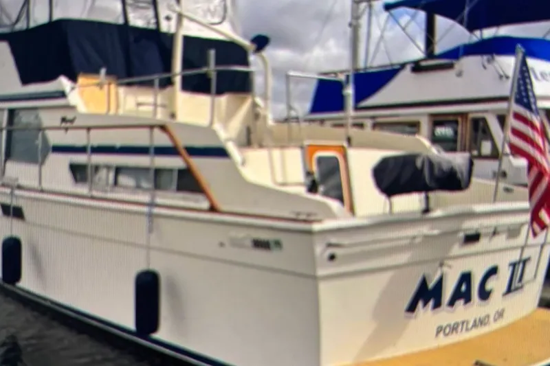 Slide: The Image of 1979 Tollycraft 40 Tri-Cabin Motor Yacht docked, displaying American flag, named "MAC II". - 22