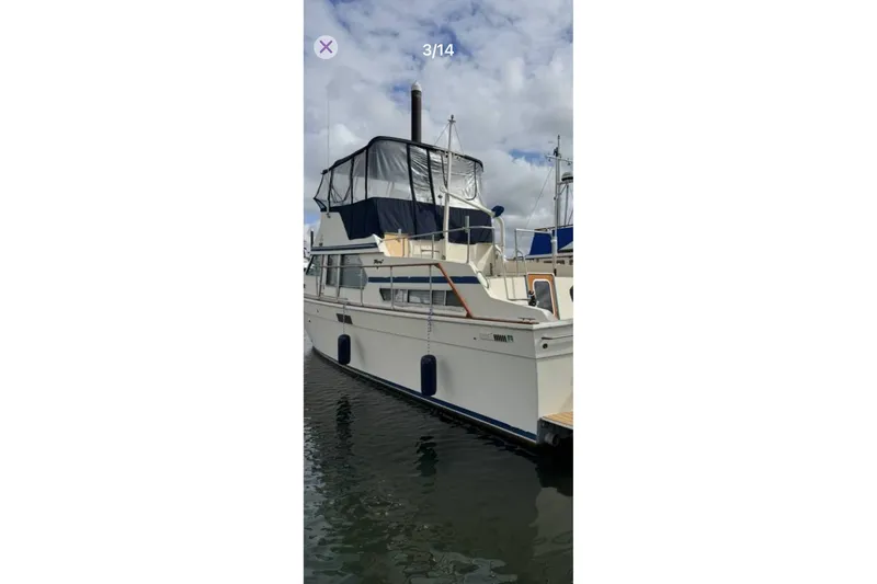 Slide: The Image of 1979 Tollycraft 40 Tri-Cabin Motor Yacht docked, featuring a covered upper deck. - 2