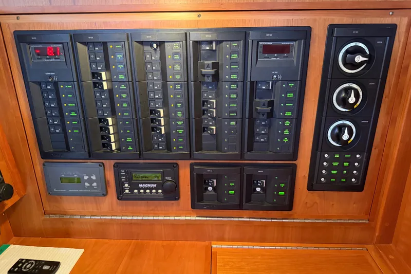 Slide: The Image of Electrical control panel on a 2011 Tartan 4300 yacht, featuring switches and gauges. - 22