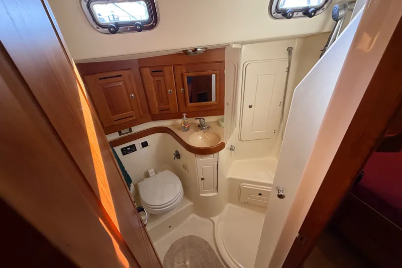 Slide: The Image of Compact bathroom in 2011 Tartan 4300 yacht with wooden cabinets and shower. - 15