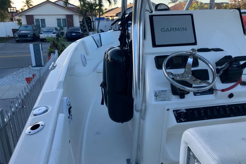 Slide: The Image of 2014 Century boat with Garmin navigation, steering wheel, and docked in a residential area. - 8