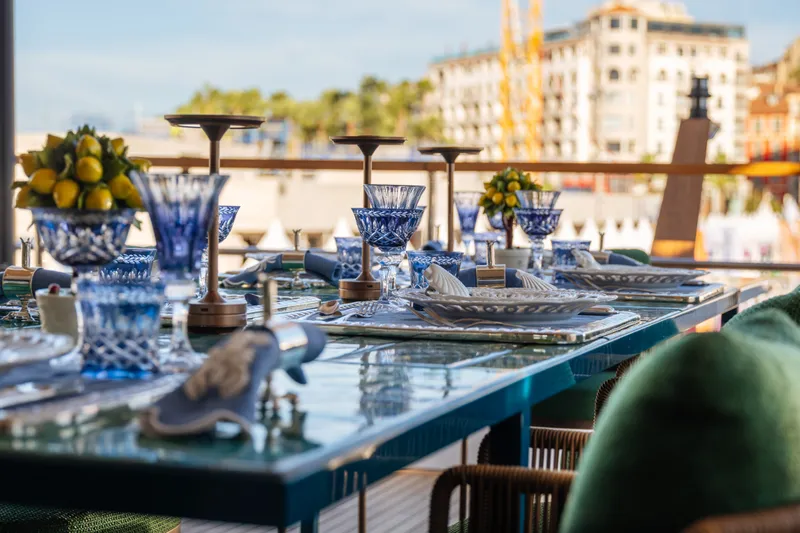 Slide: The Image of Elegant dining setup on Sirena 118 yacht, featuring blue glassware and lemon centerpieces, 2027 model. - 9