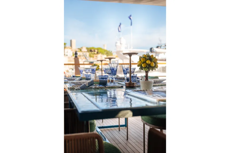Slide: The Image of Elegant dining setup on Sirena 118 yacht, featuring blue glassware and lemon centerpiece, 2027 model. - 11