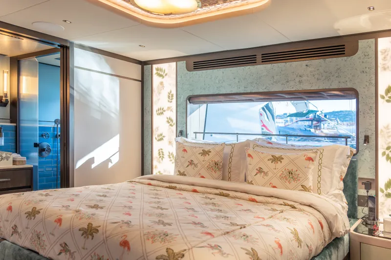 Slide: The Image of Luxurious Sirena 118 yacht bedroom interior, featuring elegant bedding and scenic ocean view, 2027 model. - 27