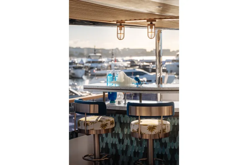 Slide: The Image of Luxurious Sirena 118 yacht bar area with stylish seating, overlooking marina, 2027 model. - 12