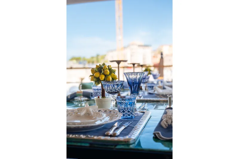 Slide: The Image of Elegant table setting with blue glassware on Sirena 118 yacht, 2027. - 13