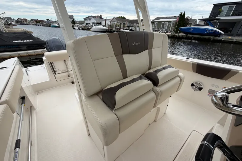 Slide: The Image of 2020 Robalo R272 Center Console boat interior with beige seating, docked by waterfront homes. - 40