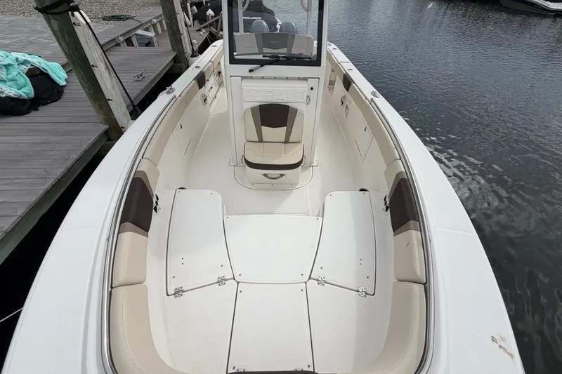 Slide: The Image of 2020 Robalo R272 Center Console boat docked, showcasing spacious seating and sleek design. - 54