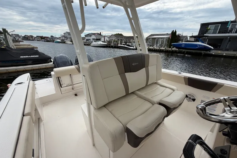 Slide: The Image of 2020 Robalo R272 Center Console boat interior with dual seating, docked by waterfront homes. - 43