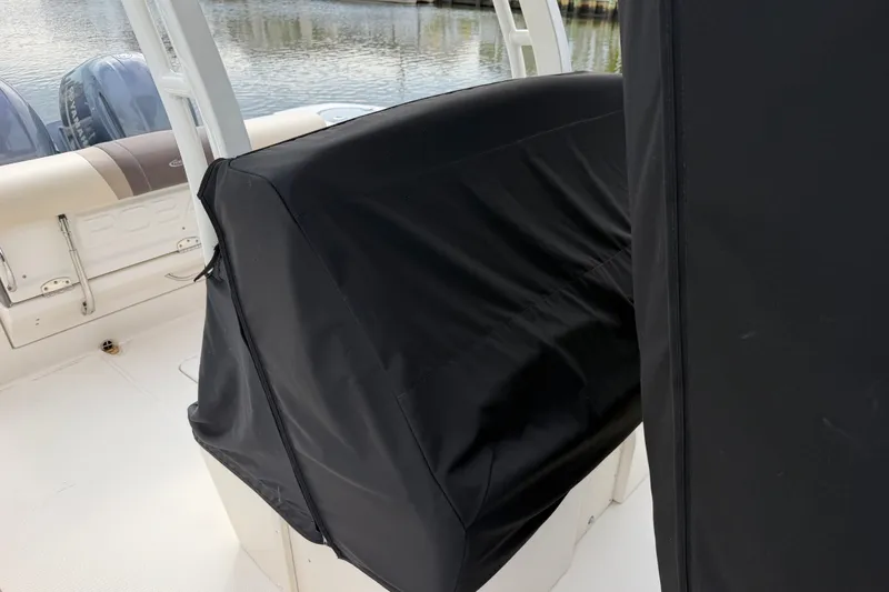 Slide: The Image of 2020 Robalo R272 Center Console boat with covered seating, docked by the water. - 61