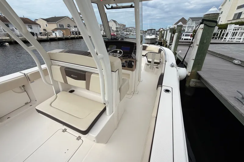 Slide: The Image of 2020 Robalo R272 Center Console boat docked at marina, showcasing interior seating and helm. - 35
