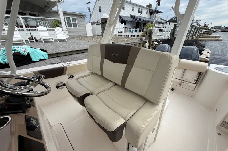 Slide: The Image of 2020 Robalo R272 Center Console boat interior with beige seating and steering wheel. - 42