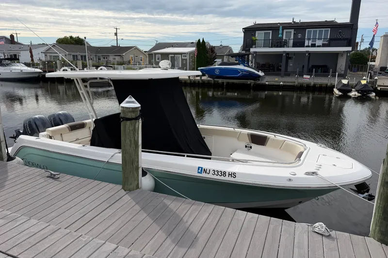 The Image of 2020 Robalo R272 Center Console boat docked by waterfront homes. - 20