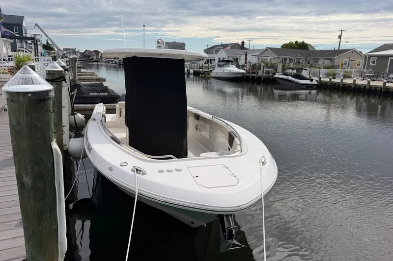 Slide: The Image of 2020 Robalo R272 Center Console boat docked in a serene marina setting. - 22