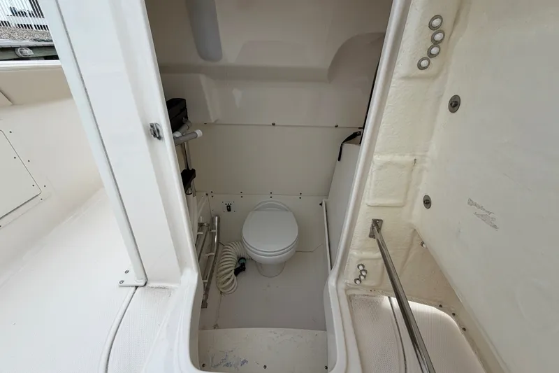 Slide: The Image of 2020 Robalo R272 Center Console boat interior with compact marine toilet. - 51