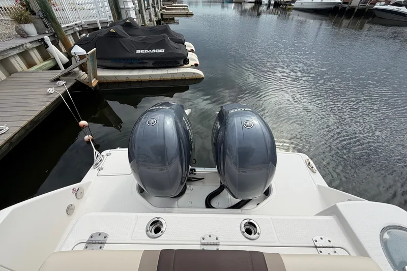 Slide: The Image of 2020 Robalo R272 Center Console boat with twin Yamaha outboard engines docked by the water. - 28