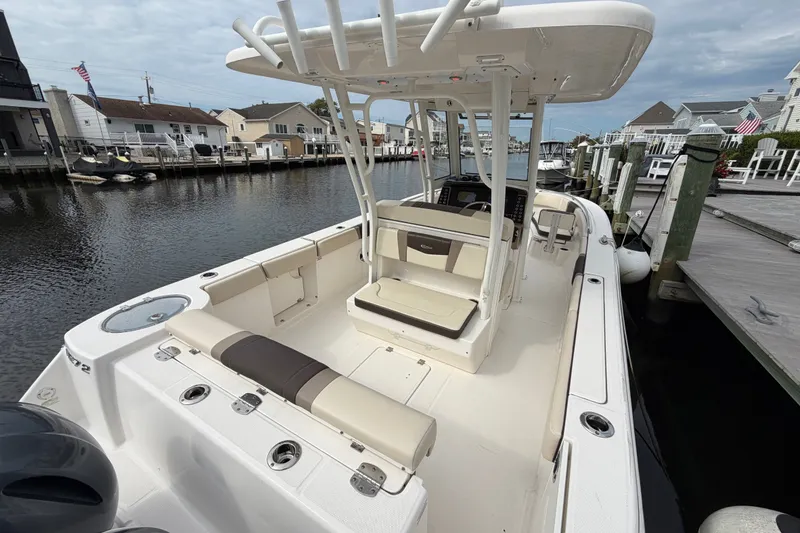 Slide: The Image of 2020 Robalo R272 Center Console boat docked in a marina, showcasing spacious seating. - 24