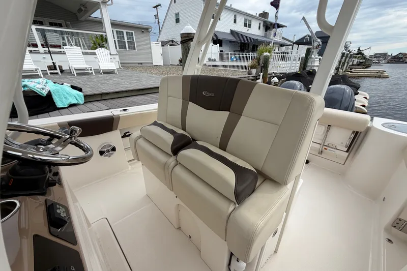 Slide: The Image of 2020 Robalo R272 Center Console boat interior with beige seating and steering wheel. - 41