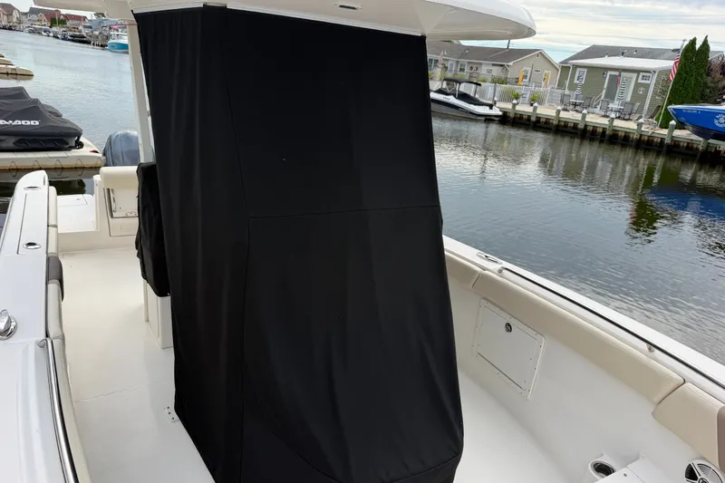 Slide: The Image of 2020 Robalo R272 Center Console boat interior with covered console, docked by waterfront homes. - 57