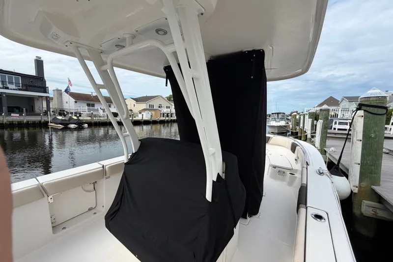 Slide: The Image of 2020 Robalo R272 Center Console boat docked at a marina with covered seating. - 59