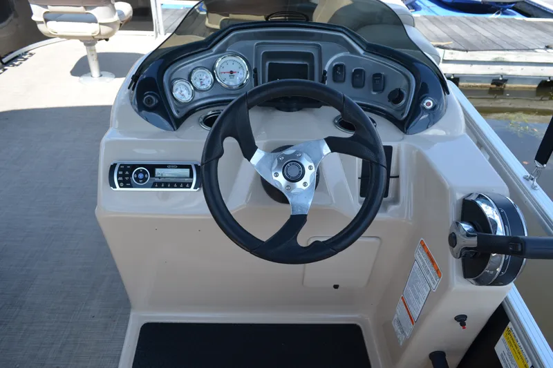 Slide: The Image of 2019 Sun Tracker Fishin' Barge 20 DLX helm with steering wheel and control panel. - 23