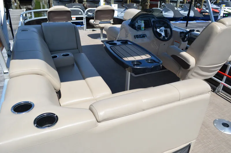 Slide: The Image of 2019 Sun Tracker Fishin' Barge 20 DLX interior with beige seating and steering console. - 19