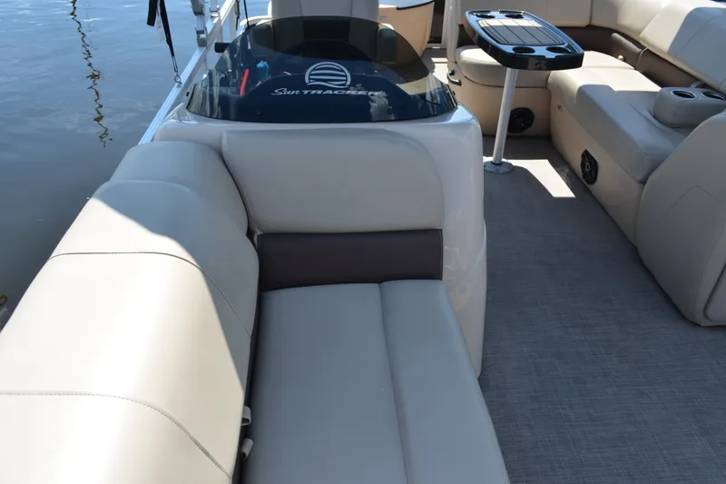 Slide: The Image of 2019 Sun Tracker Fishin' Barge 20 DLX interior with seating and table on water. - 13