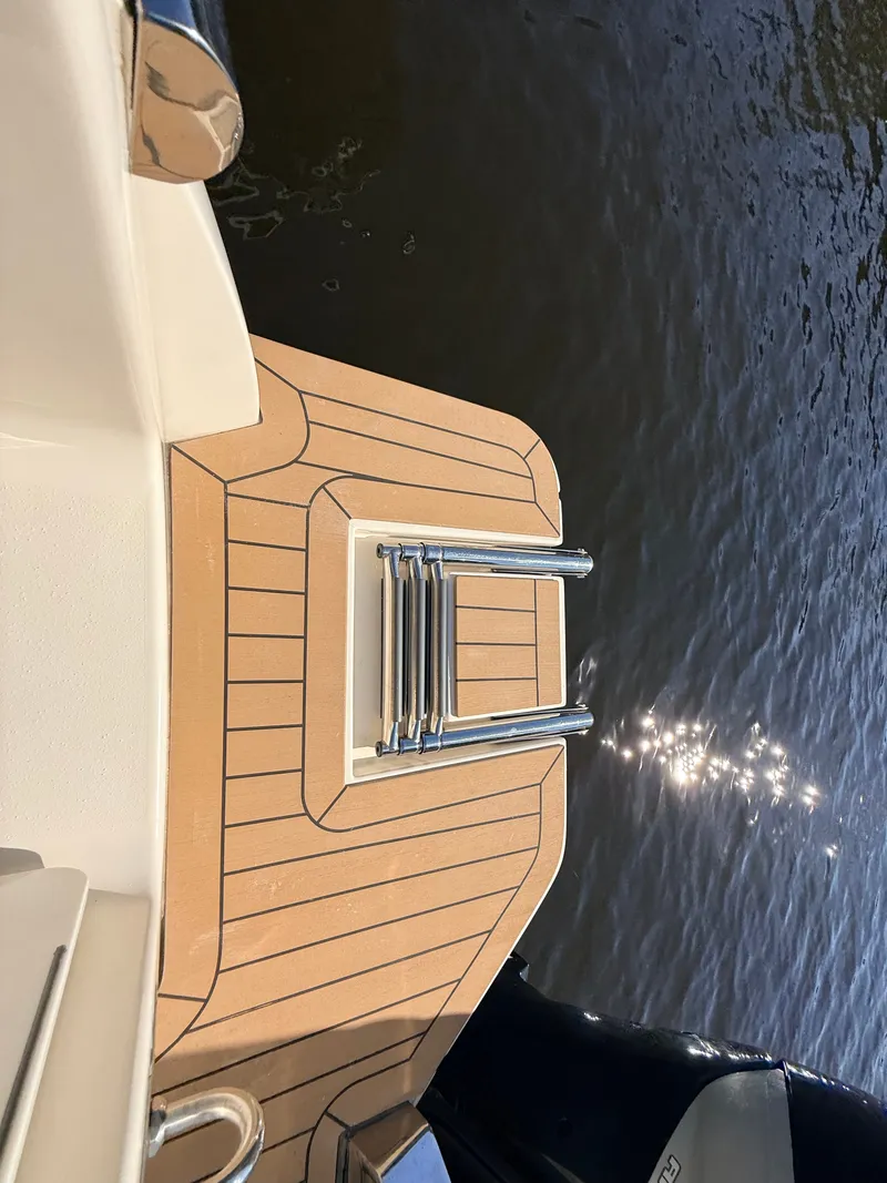 Slide: The Image of The 2018 Scout 235 XSF features a teak platform with a stainless steel ladder at the stern. - 18
