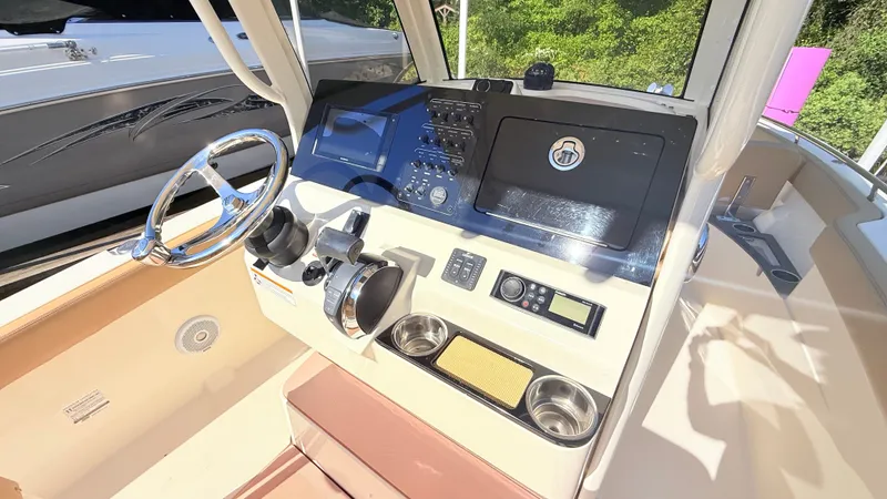 Slide: The Image of The image shows the helm of a 2018 Scout 235 XSF boat with modern controls. - 12