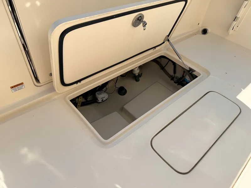 Slide: The Image of An open storage compartment on a 2018 Scout 235 XSF boat. - 14