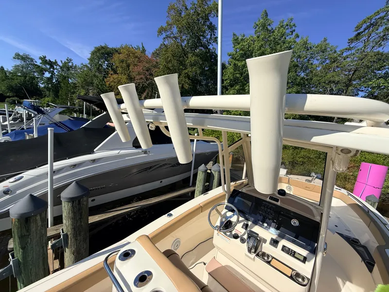 Slide: The Image of 2018 Scout 235 XSF with spacious cockpit and modern helm, docked alongside other boats. - 21