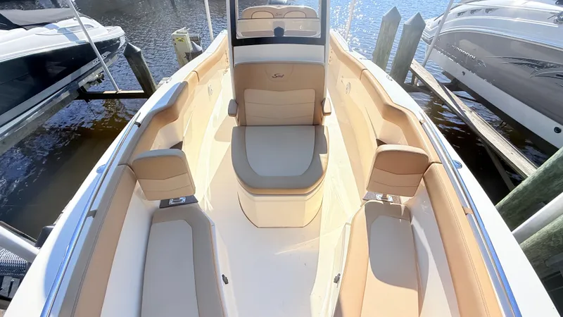 Slide: The Image of The image shows the interior of a 2018 Scout 235 XSF boat with beige seating. - 6